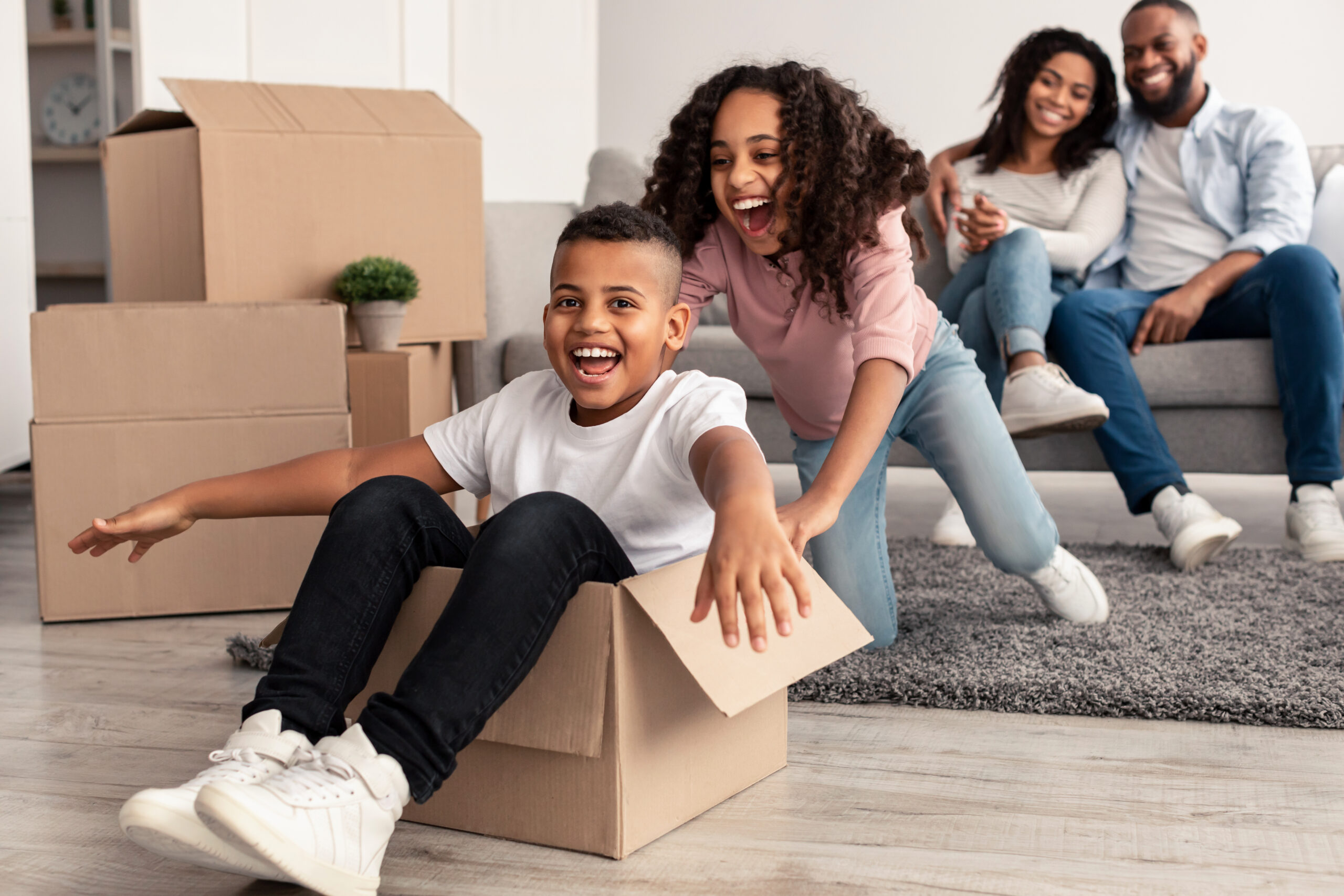 A family relaxing among moving boxes in their new home