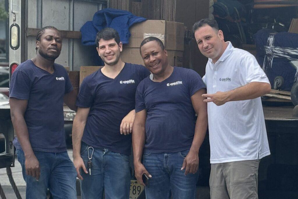 The Expedite Moving crew standing at the back of a loaded moving truck