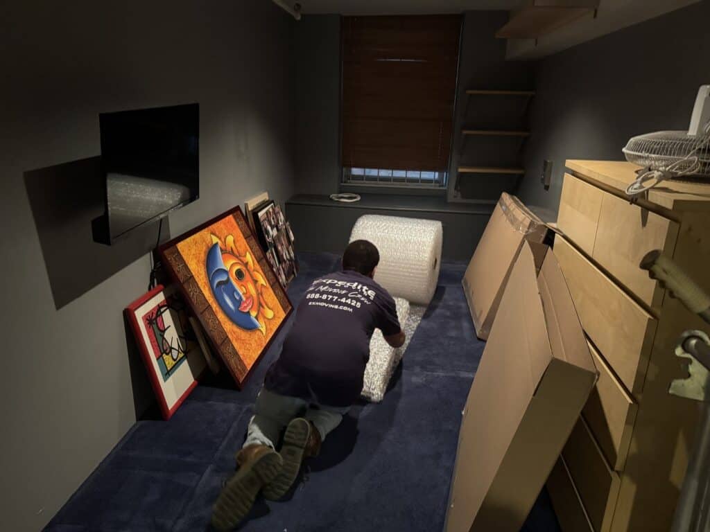 Expedite Moving mover packing framed artwork in bubble wrap